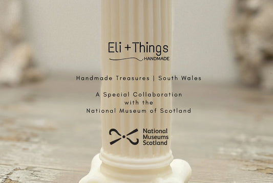 An announcement graphic for Eli + Things Handmade featuring the text: 'A Special Collaboration with the National Museum of Scotland' alongside the National Museums Scotland logo, set against a backdrop of a handmade Roman column candle