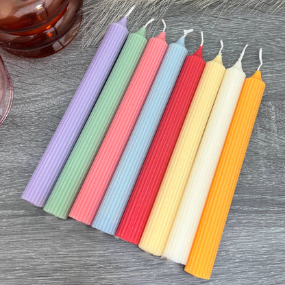 Colourful ripped dinner candles in soft pastel colours